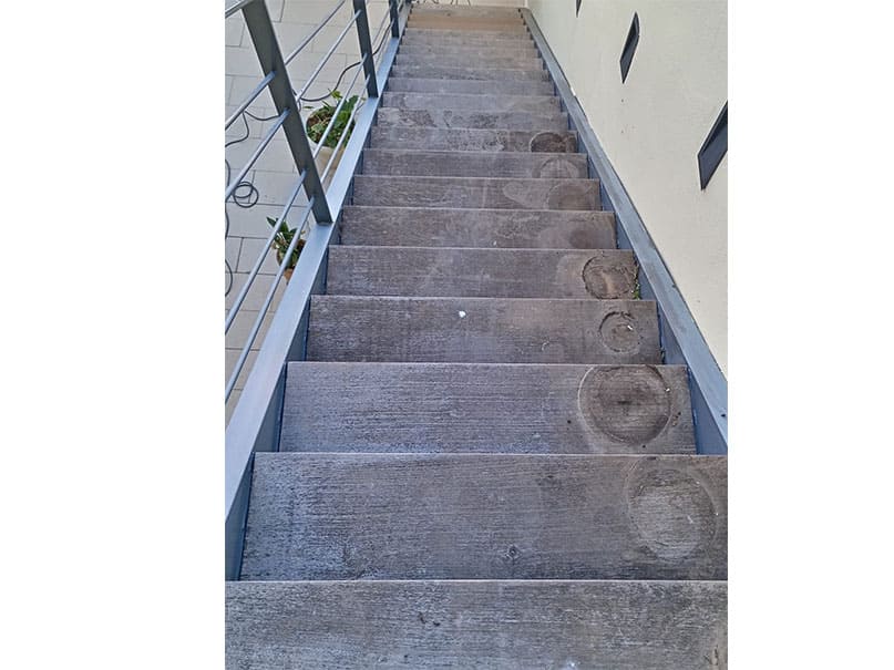 Escalera exterior renovada con barnizado profesional